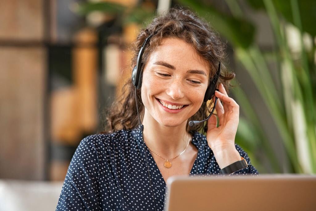 Freundliche Mitarbeiterin von elders&freunde mit Headset am Telefon